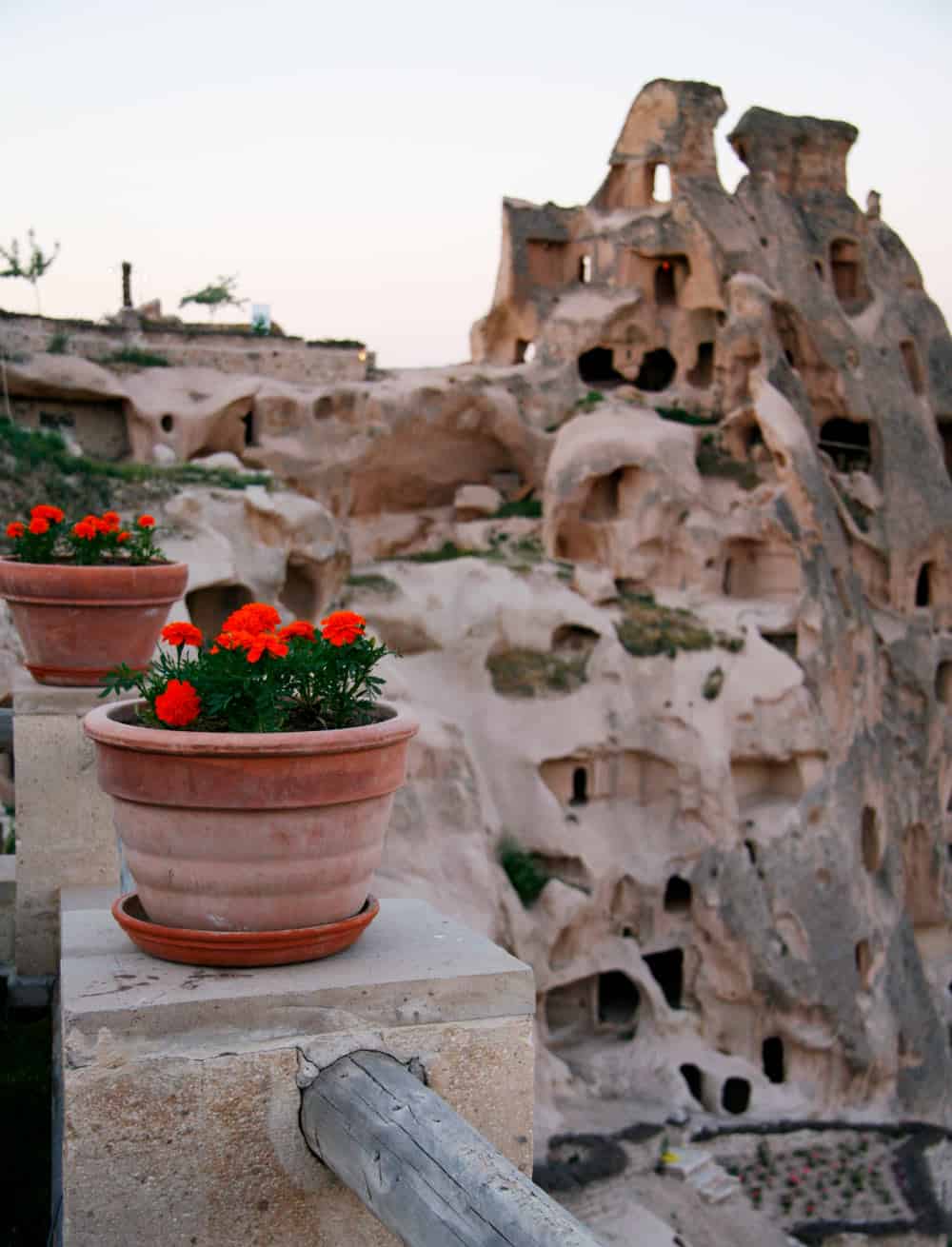Two red geranium pots beneath Uchisar Castle