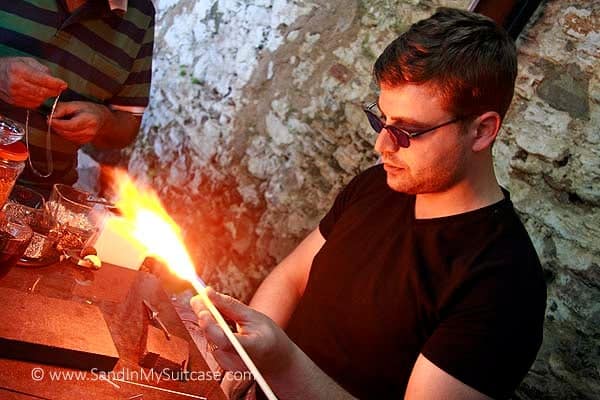 An artisan crafts glass jewelry in Sirence