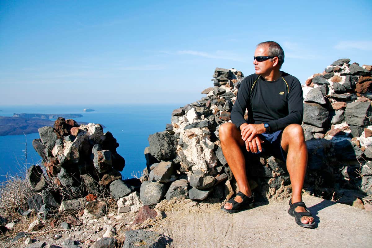 Man in black shirt looking at the view from Skaros Rock, Santorini