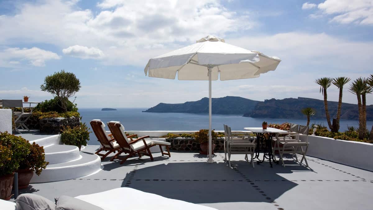 Sea views from a terrace with loungers and sun umbrella at IKIES