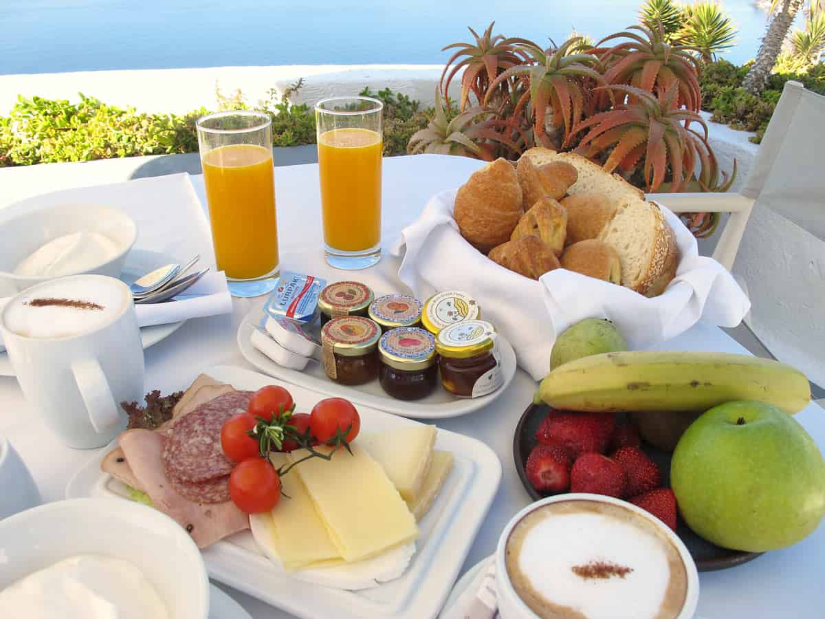 Orange juice, fruit, sliced meat for breakfast at IKIES Hotel in Santorini