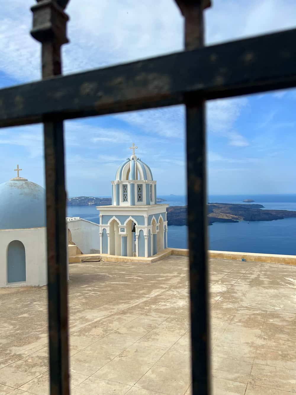 Pale blue church dome seen through metal gate