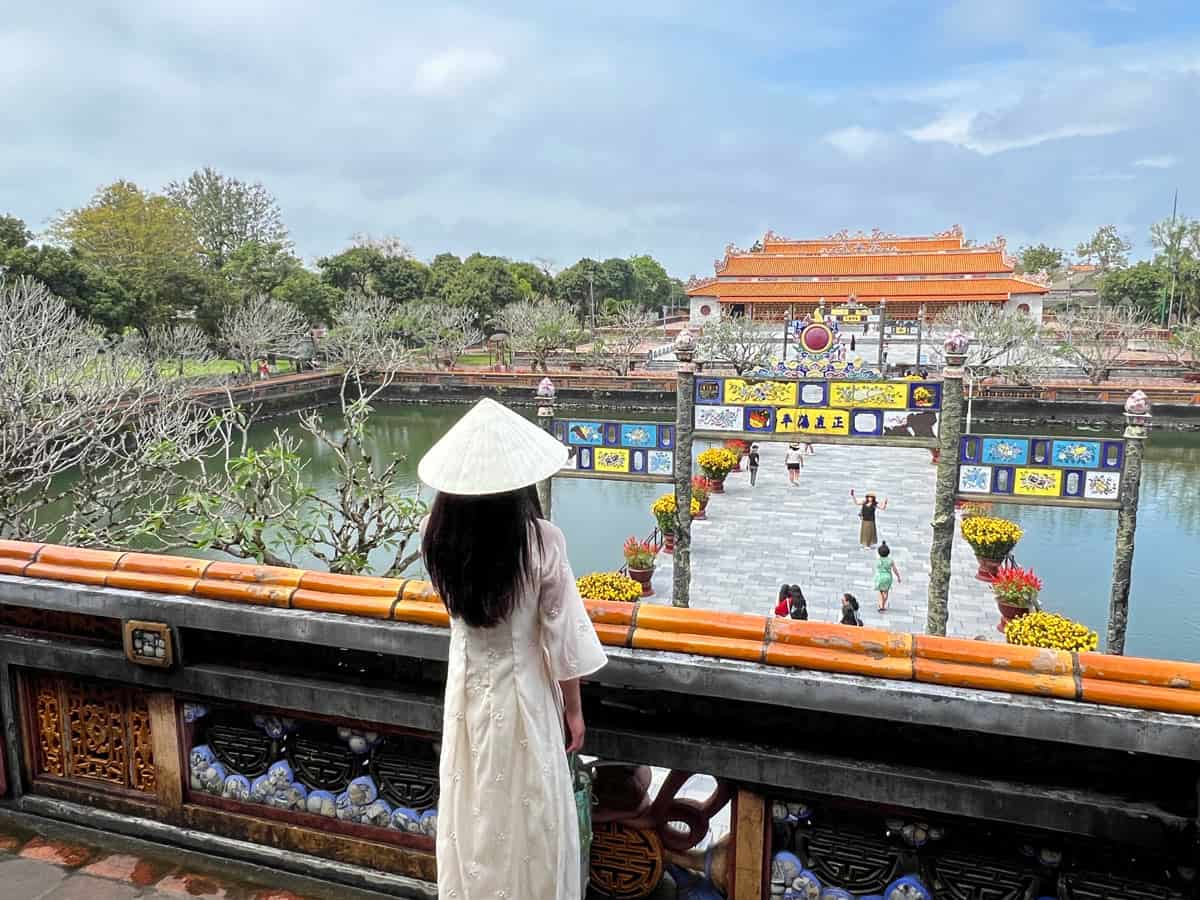 Vietnamese woman looking at ancient palace in Hue