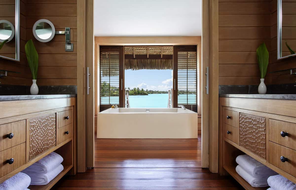 Bathroom with wood floors, double vanities and a huge soaking tub facing Bora Bora's turquoise lagoon