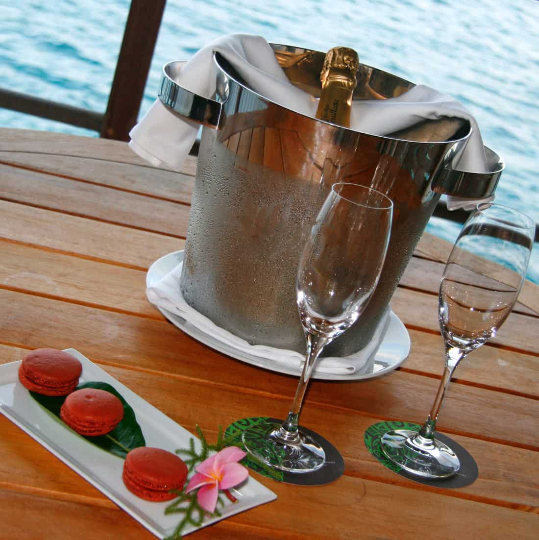 Champagne bucket with two glasses and red macarons