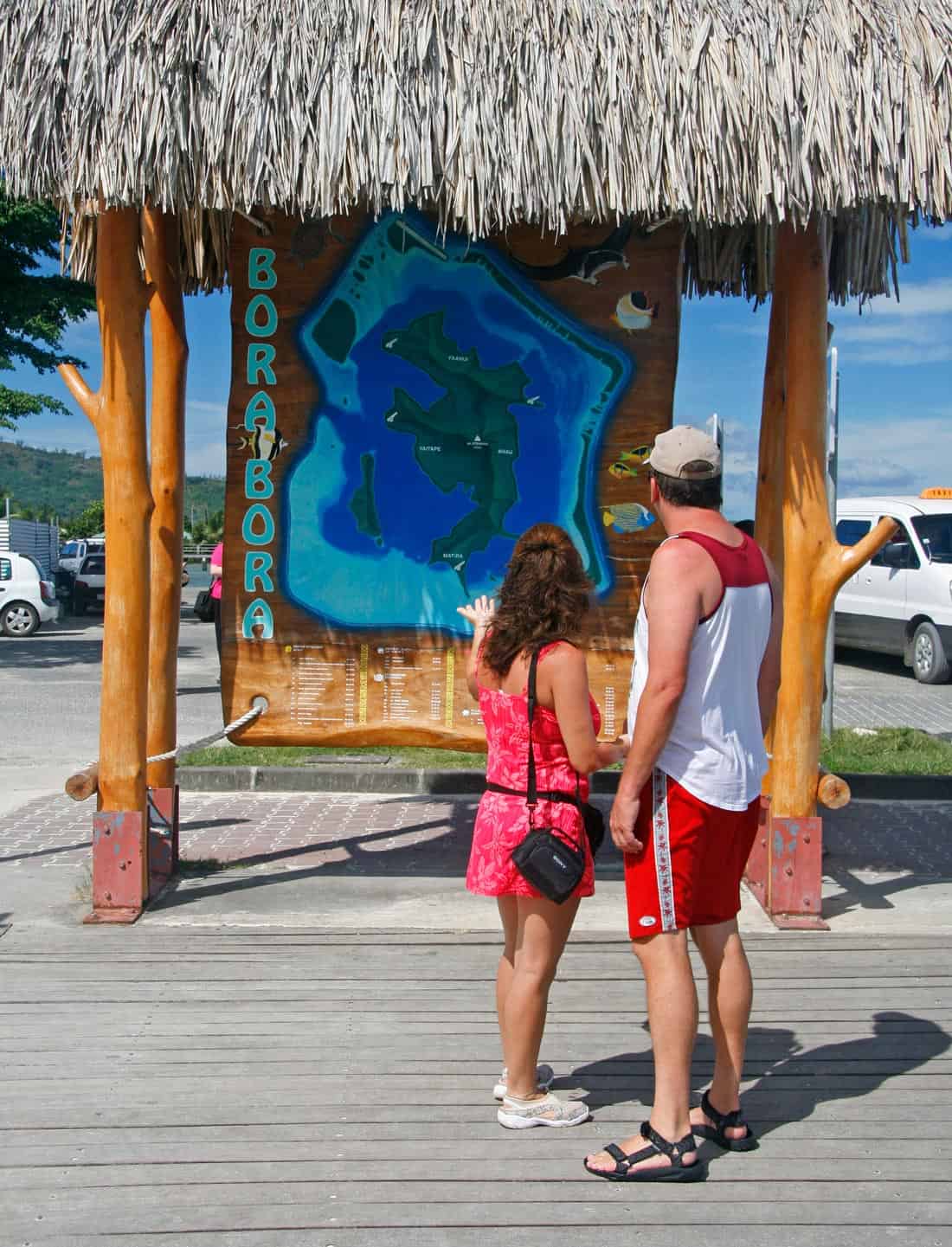 Couple reading the Bora Bora map at the Vaitape ferry dock