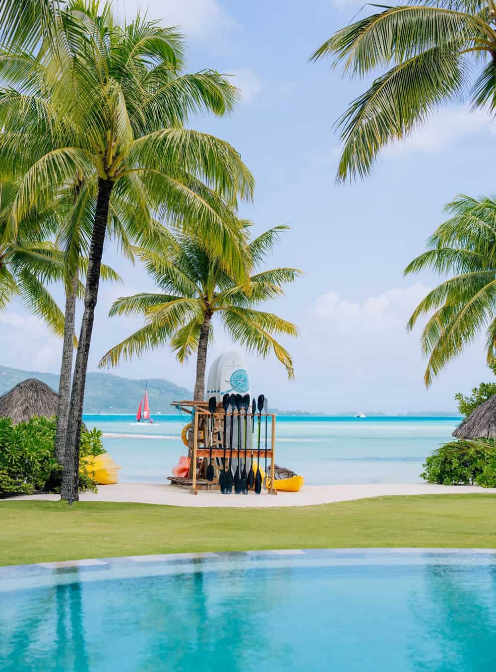 SUP boards and yellow canoes on white sand beach