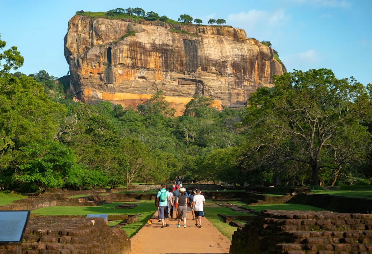 Golden rock of Sigiriya with green trees at the base