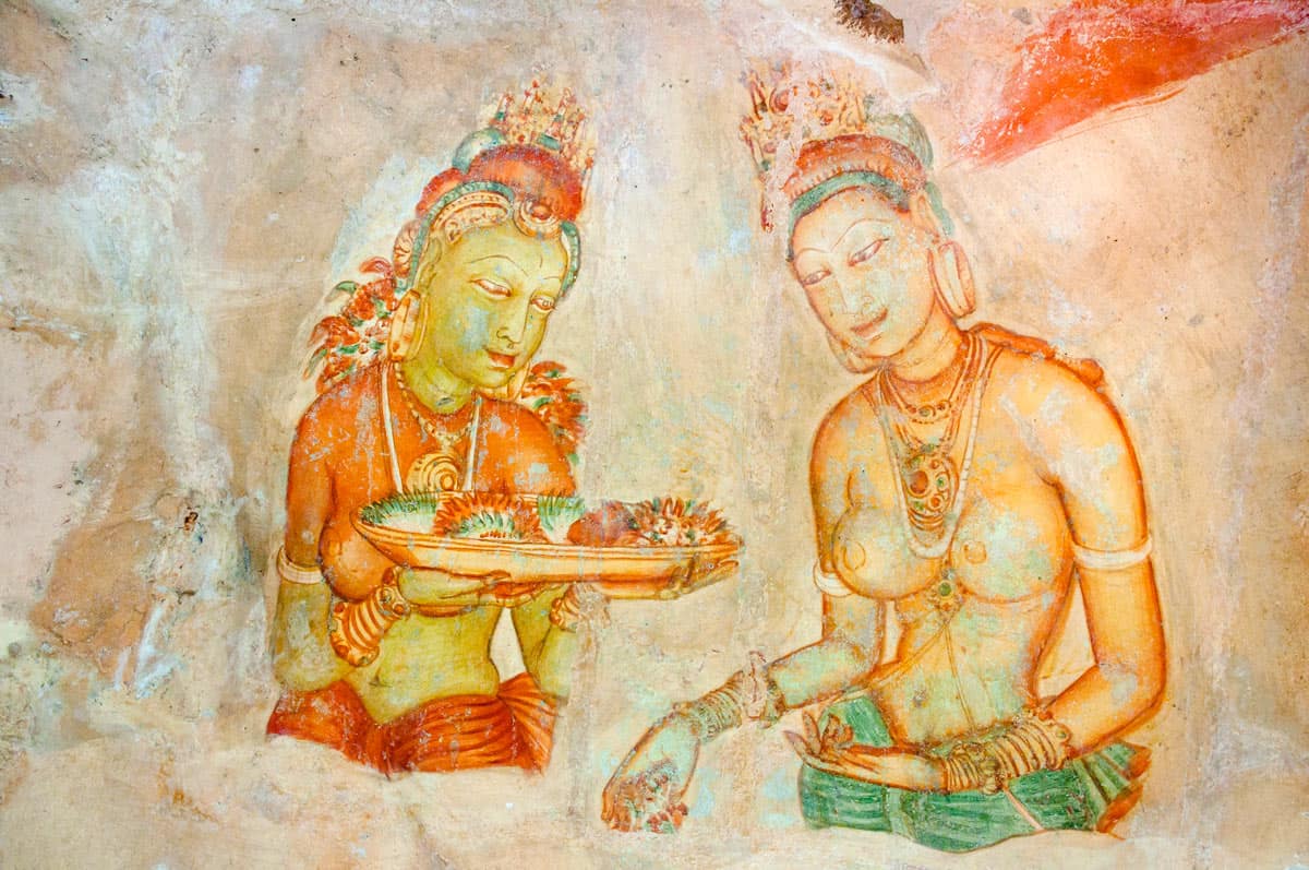 Gold and red frescoes of two bare-breasted ladies