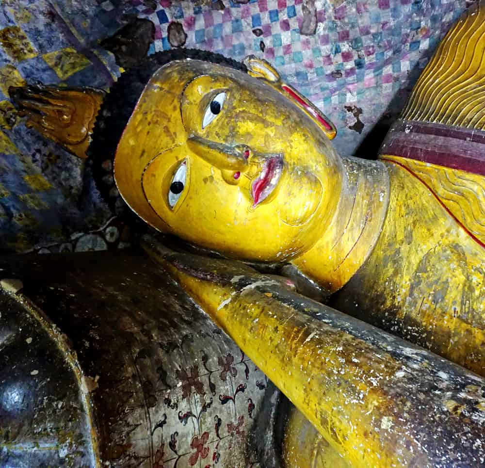 Golden face of a Buddha inside the Dambulla cave complex