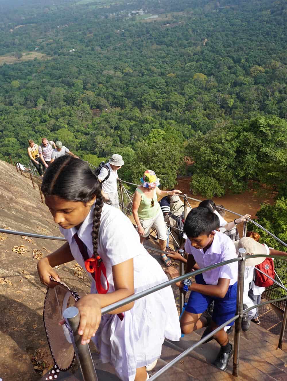 School children and visitors climb up Sigiriya Rock