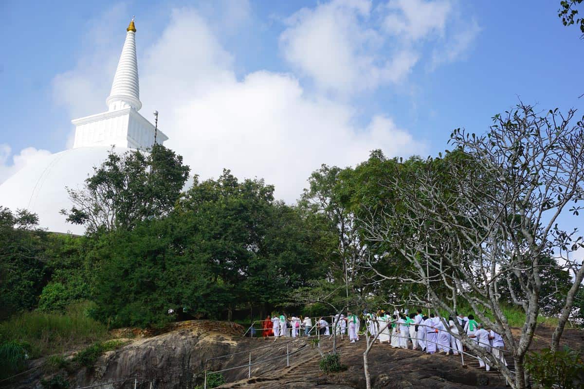 White-robed pilgrims make their way up to Mihintale’s gleaming Maha Seya stupa
