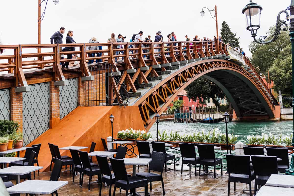 Visitors stand on the wooden Accademia Bridge in Venice, Italy