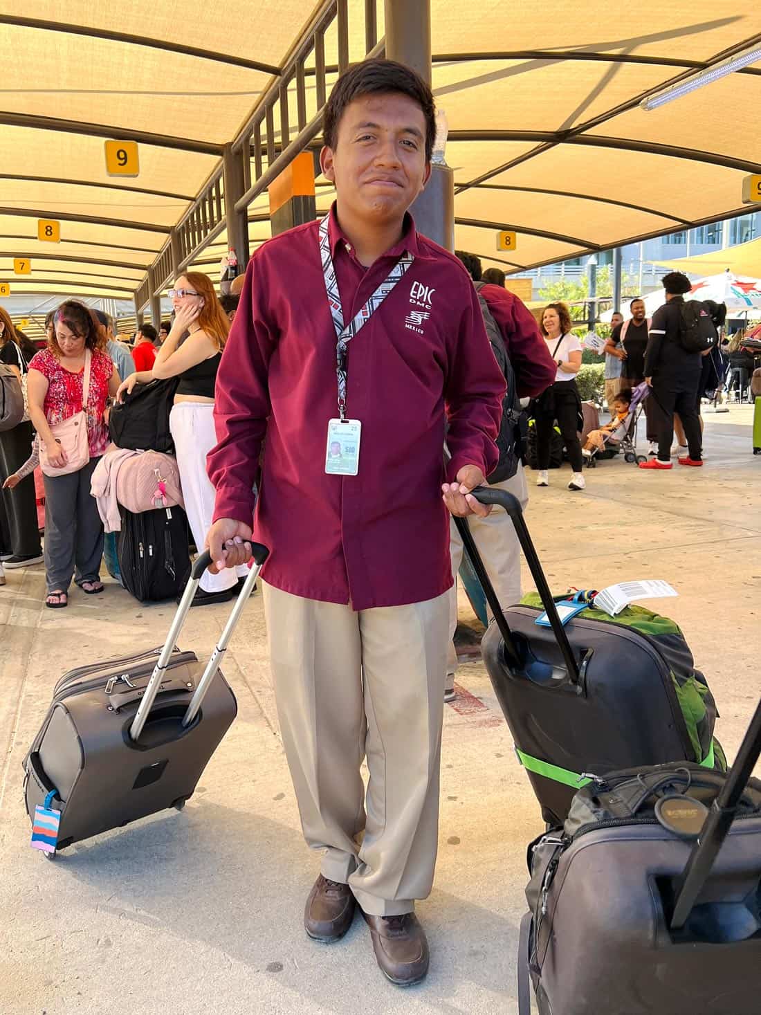 An Epic Los Cabos greeter in a burgundy shirt, handles luggage for a private transfer from the Cabo airport.