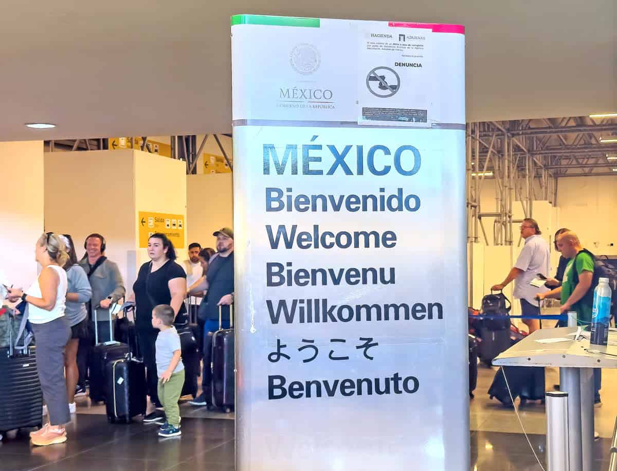People standing in line with suitcases at Arrivals in SJD to go through Customs