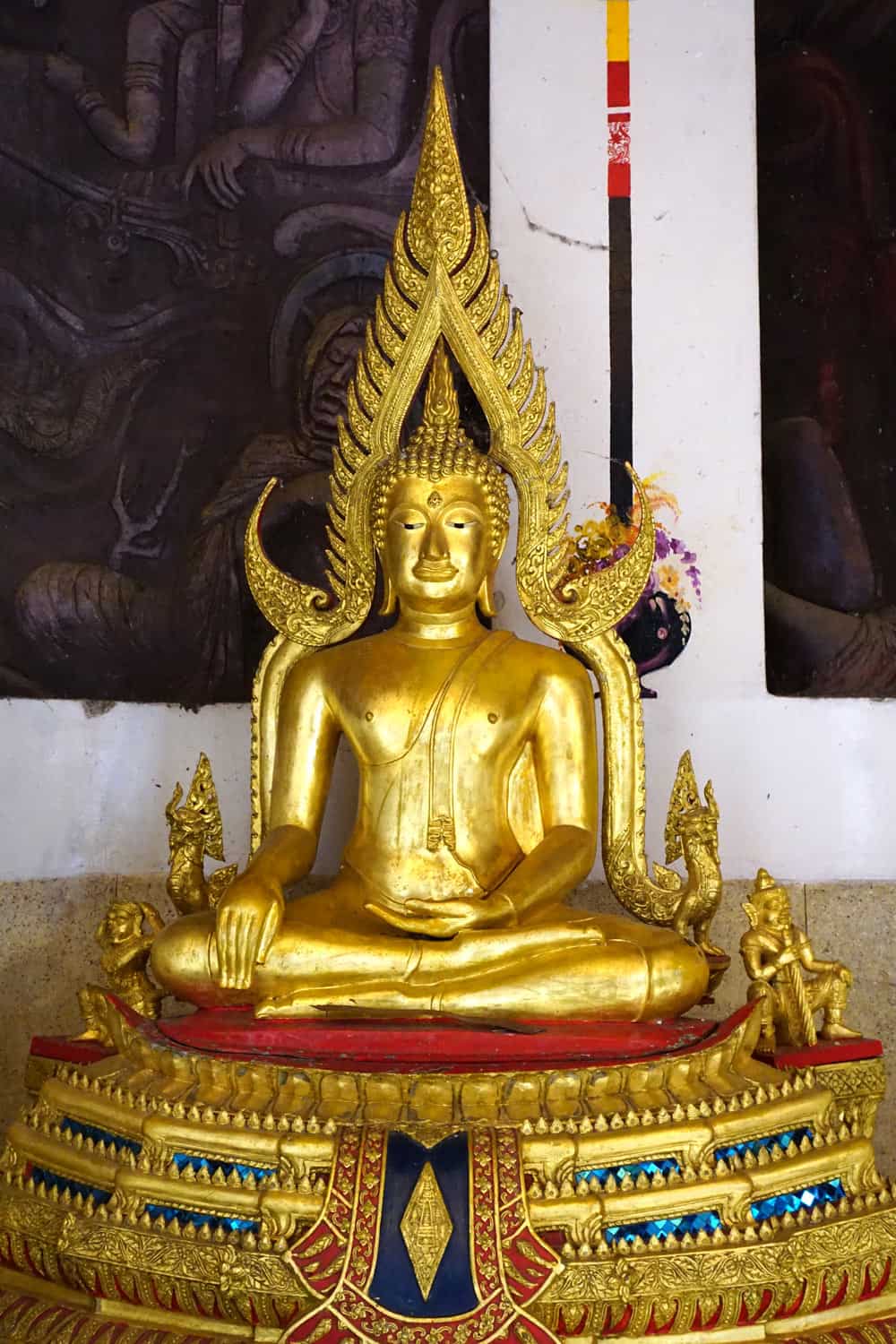 Ornate golden seated Buddha statue with a flame-shaped halo and colorful blue-and-red detailing at Bahiravokanda Vihara