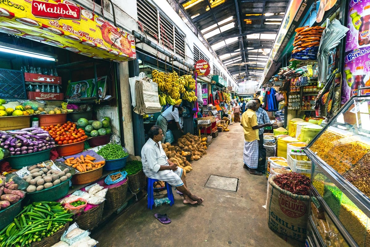 Indoor Kandy market with stalls piled high with colorful fruits, vegetables and spices
