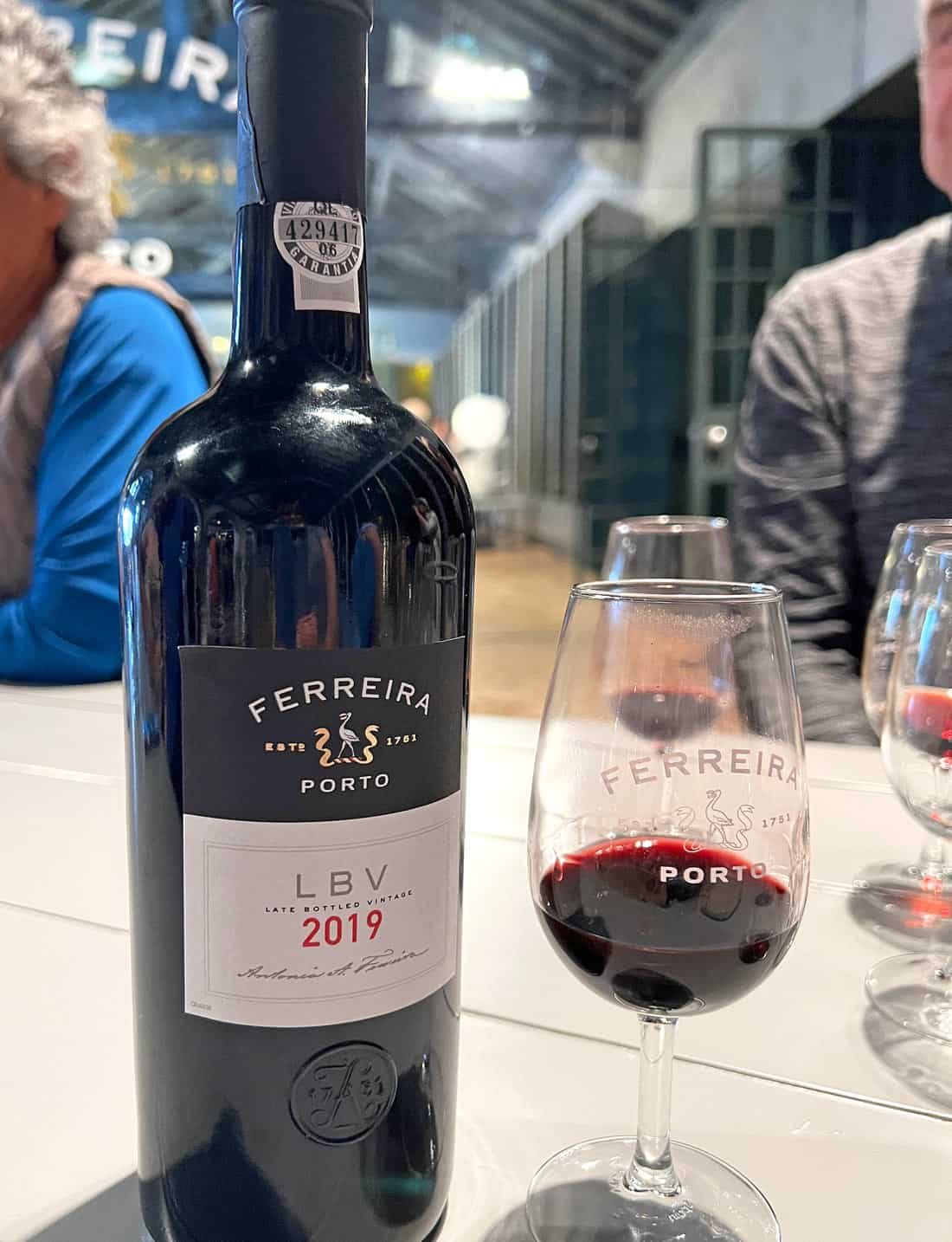 Port wine bottle and glass of port at Ferreira Cellar in Porto