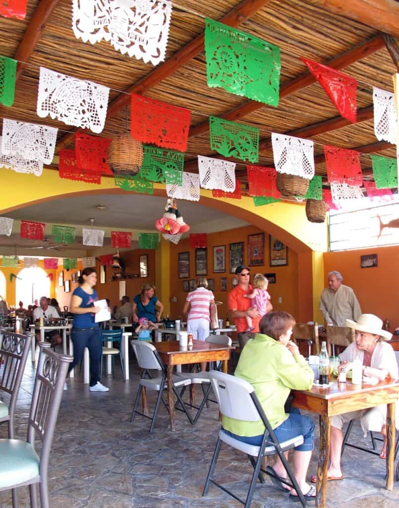 Colorful red, white and green papel picado decorations hang above diners at Tacos Gardenias in Cabo San Lucas.