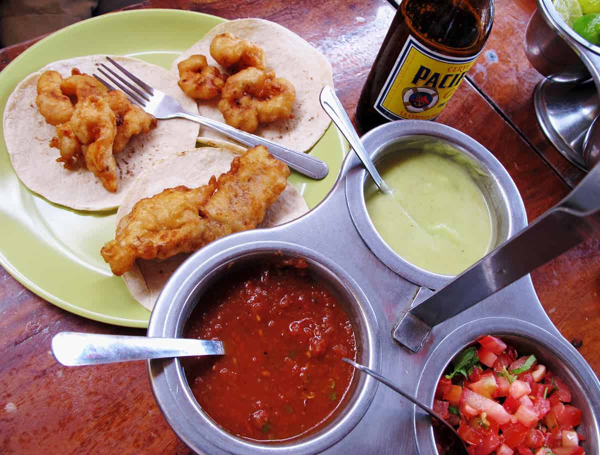 Crispy shrimp and fish tacos served with fresh salsa, creamy green sauce and a cold Pacifico beer at Tacos Gardenias