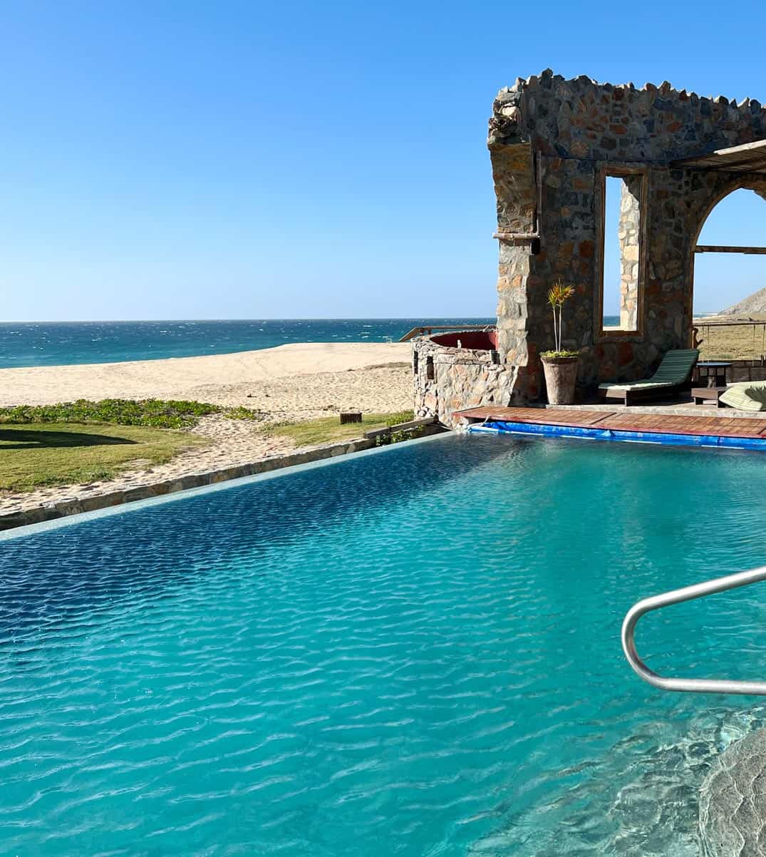 Turquoise infinity pool overlooking a deserted sandy beach and the Pacific Ocean near Todos Santos, Mexico