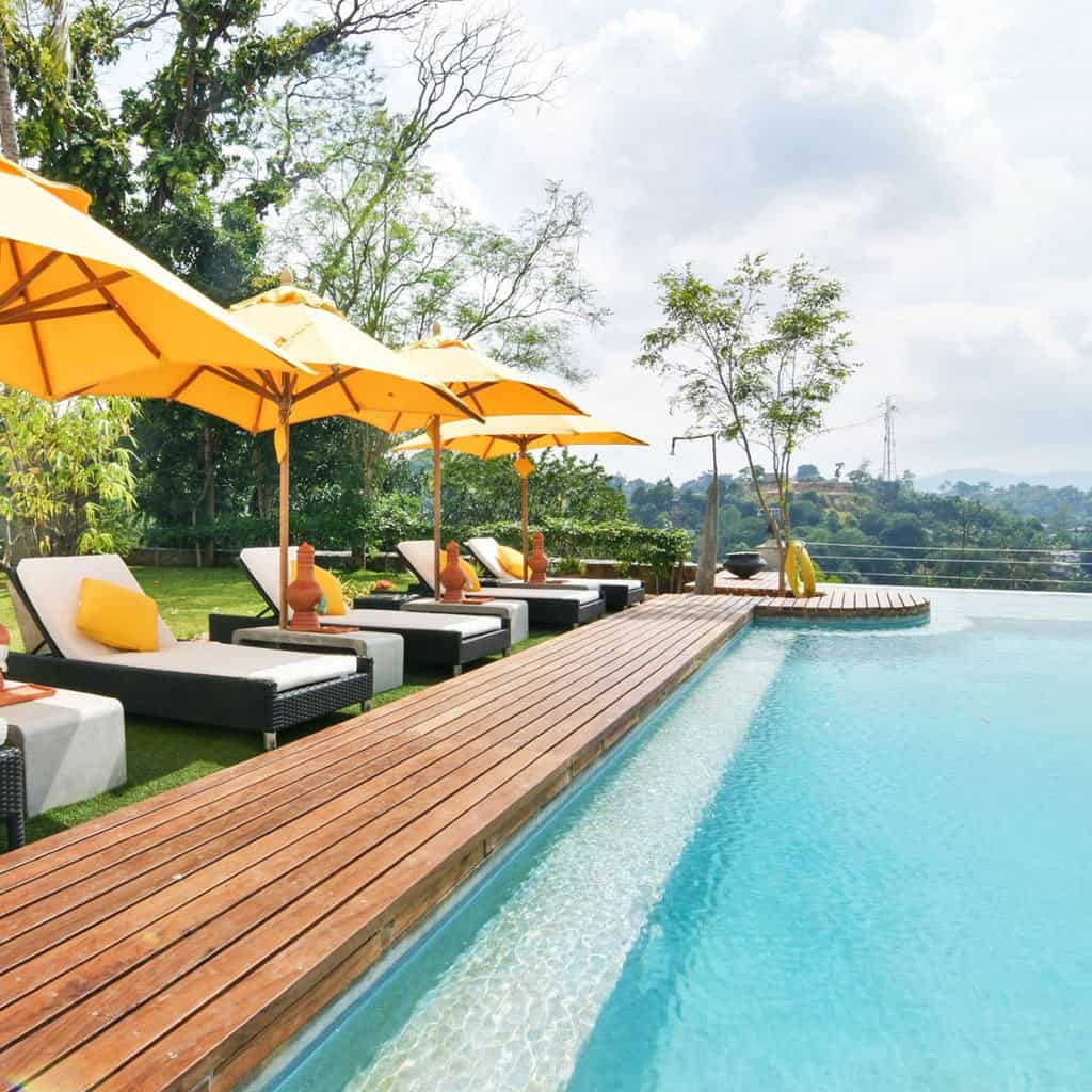 Yellow umbrellas and deck chairs by a blue swimming pool