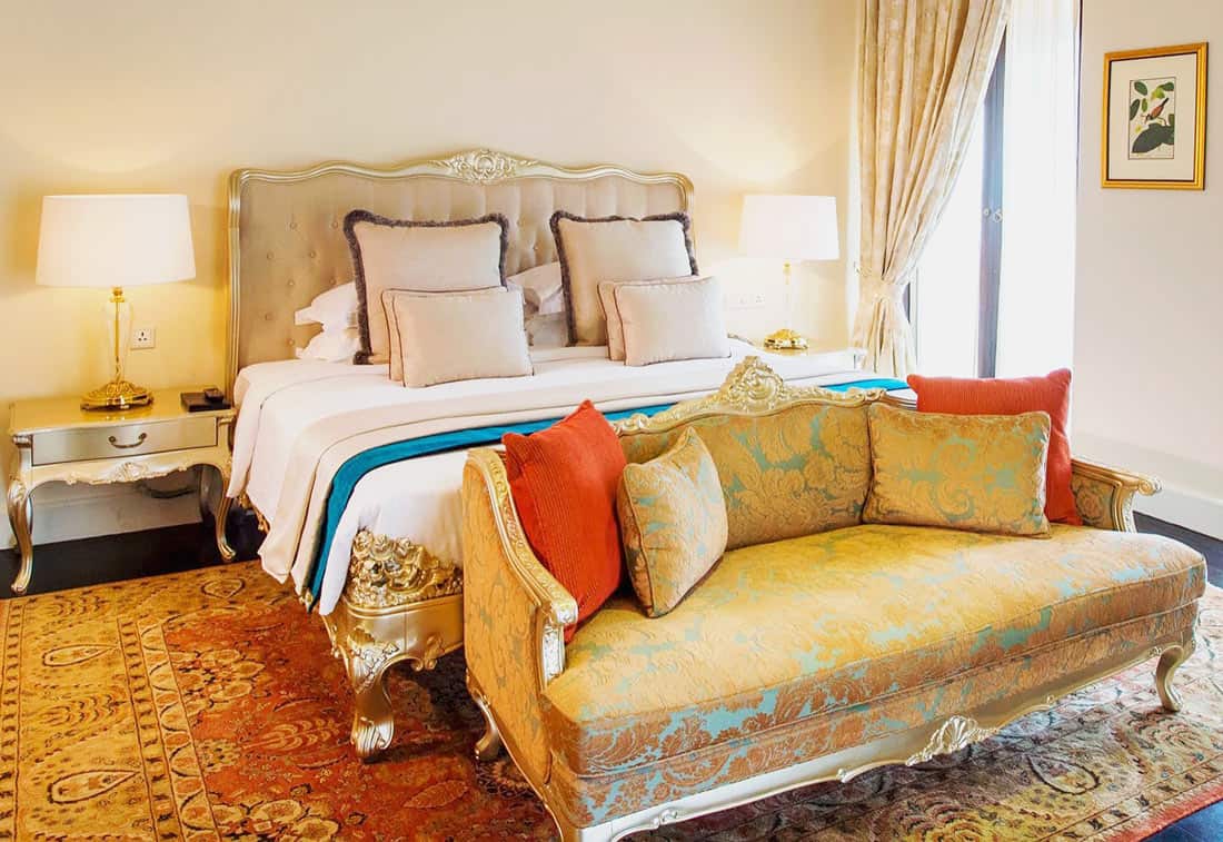 Galle Face Hotel suite with gilt-framed bed and gold satin loveseat
