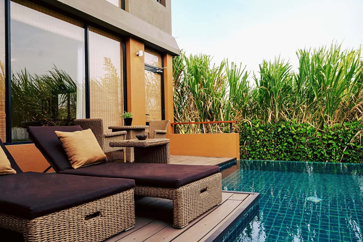 Small turquoise-tiled dipping pool by a deck with two rattan loungers