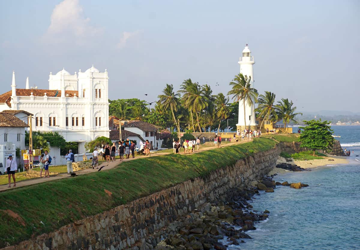 White Galle Fort lighthouse and palm-lined ramparts overlooking the Indian Ocean in Galle, Sri Lanka