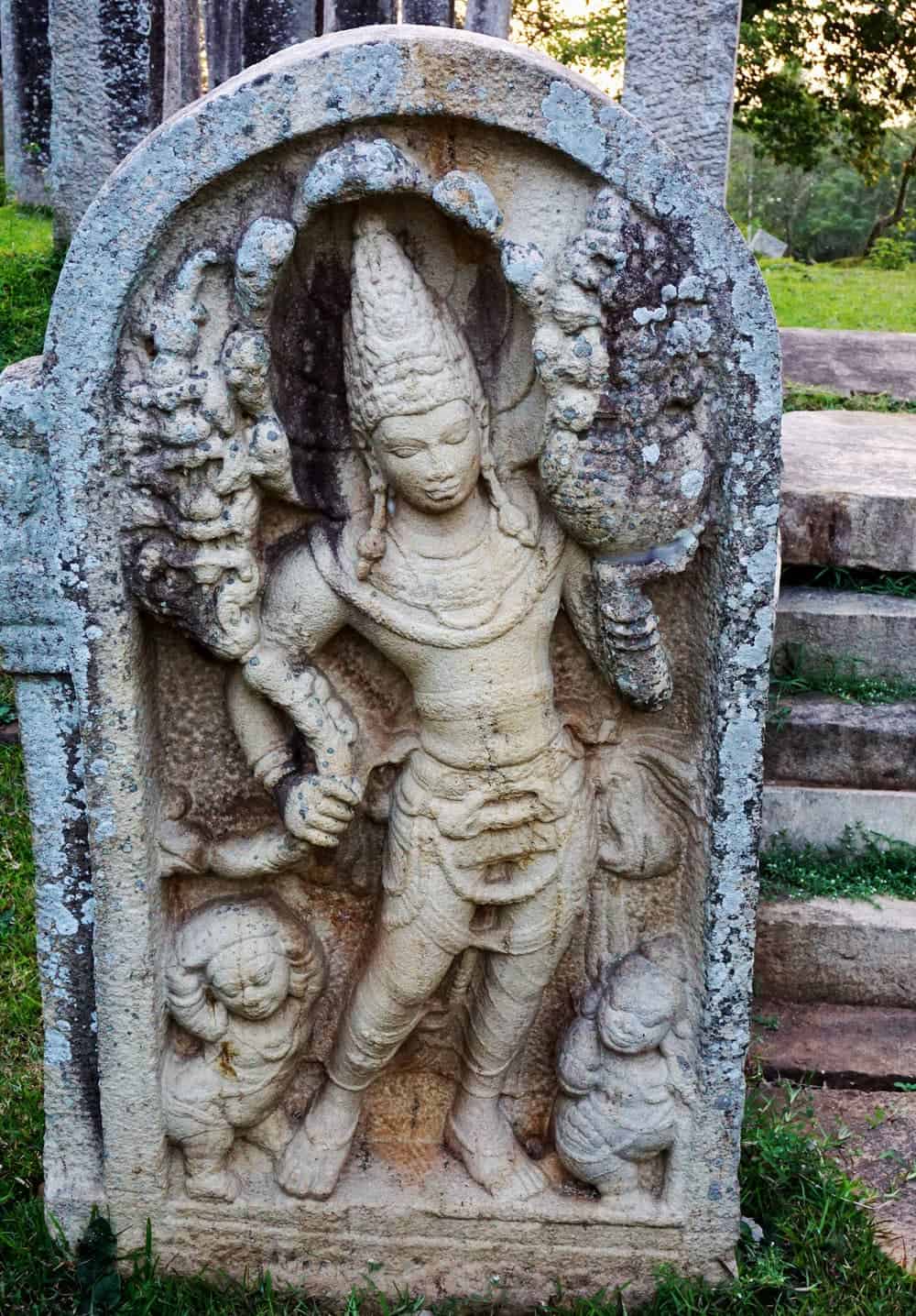 Weathered stone guardian carving at an ancient temple site in Anuradhapura, Sri Lanka