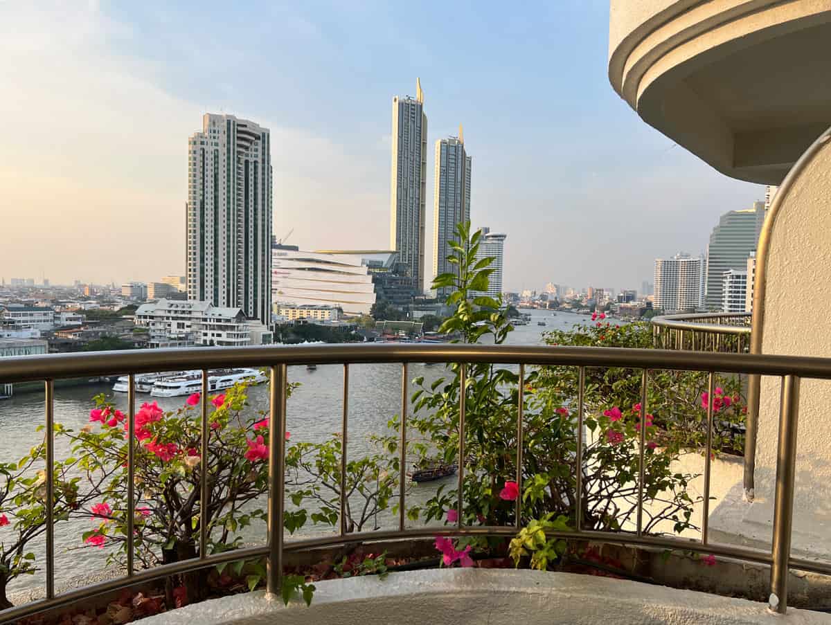 Private Krungthep Wing balcony at Shangri-La Bangkok with pink bougainvillea and sweeping views over the Chao Phraya River and city skyline