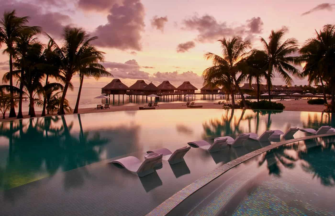 Conrad Bora Bora infinity pool with pink glow at sunset