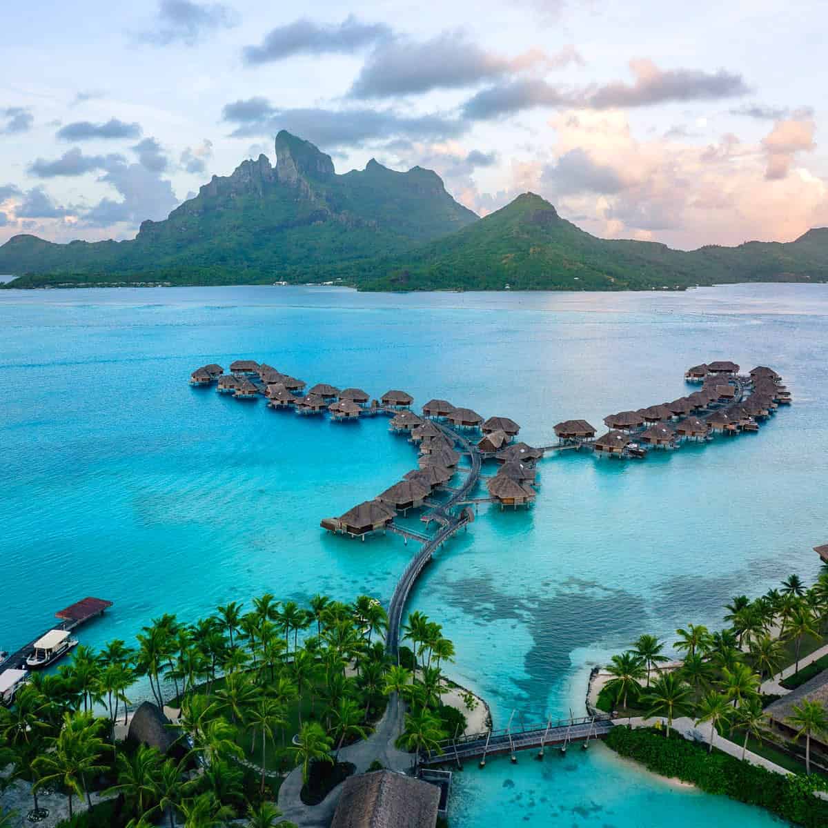 Four Seasons Bora bora overwater bungalows with pink clouds behind Mount Otemanu