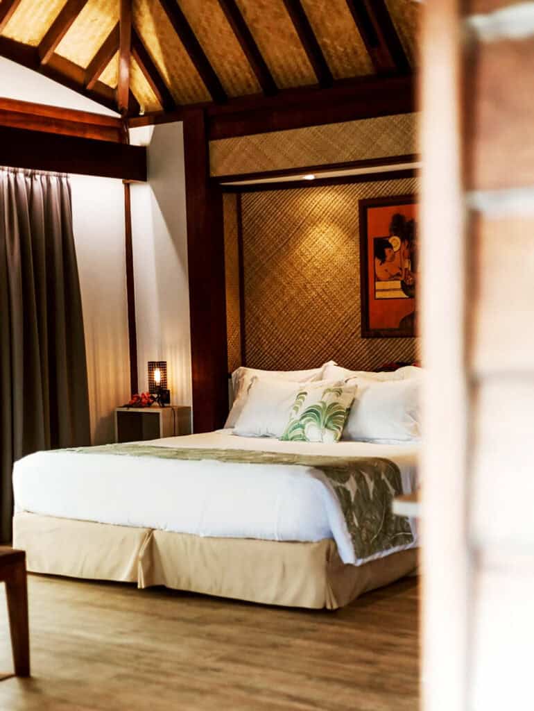Bedroom with wood floors and king bed of Maitai Polynesia in Bora Bora