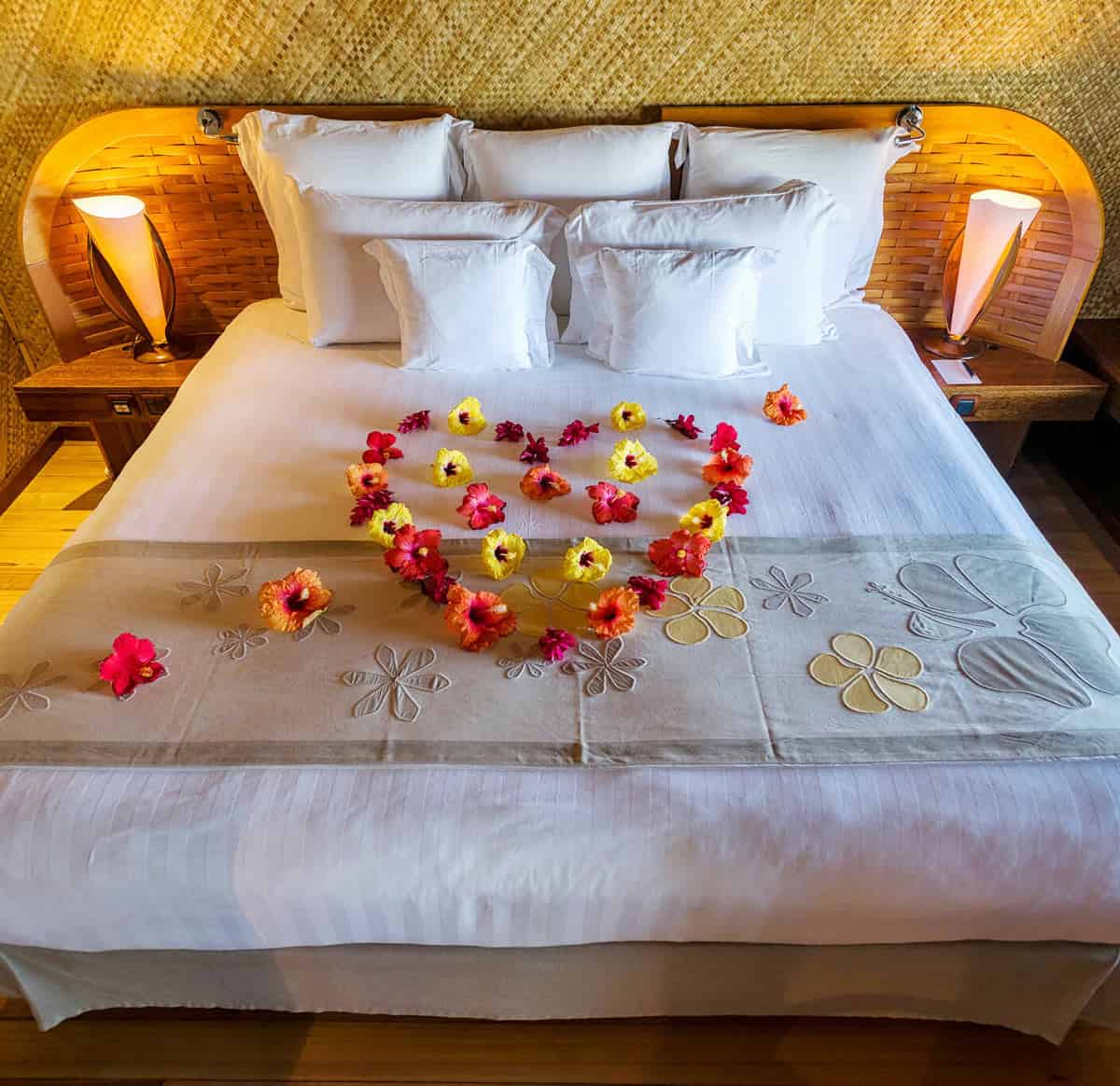 Bed sprinkled with yellow and pink flowers at InterContinental Bora Bora Le Moana