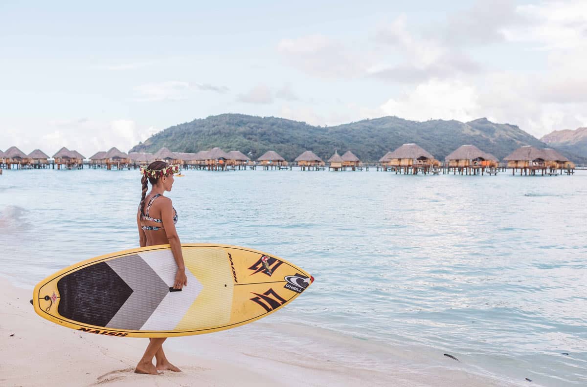 Young woman with surf board at Le Bora Bora