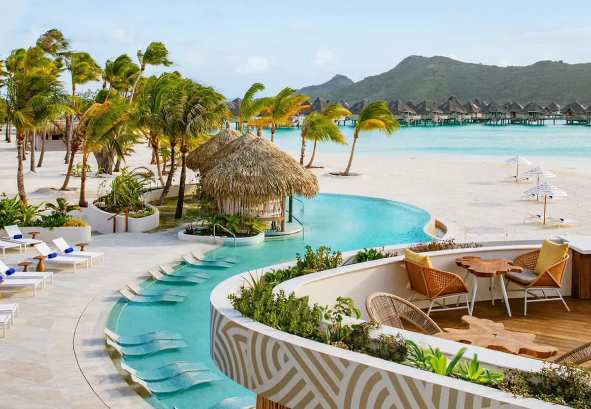 Winding blue pool of Westin Bora Bora overlooking white sand beach