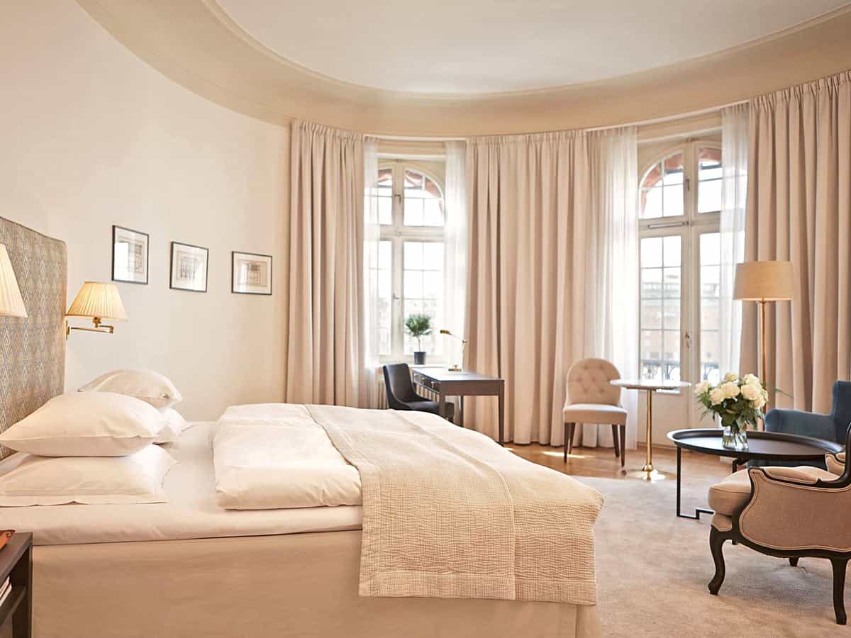 A Junior Sea View Suite at Stockholm's Hotel Diplomat, with soft ivory and cappuccino-colored carpet, drapes and furnishings