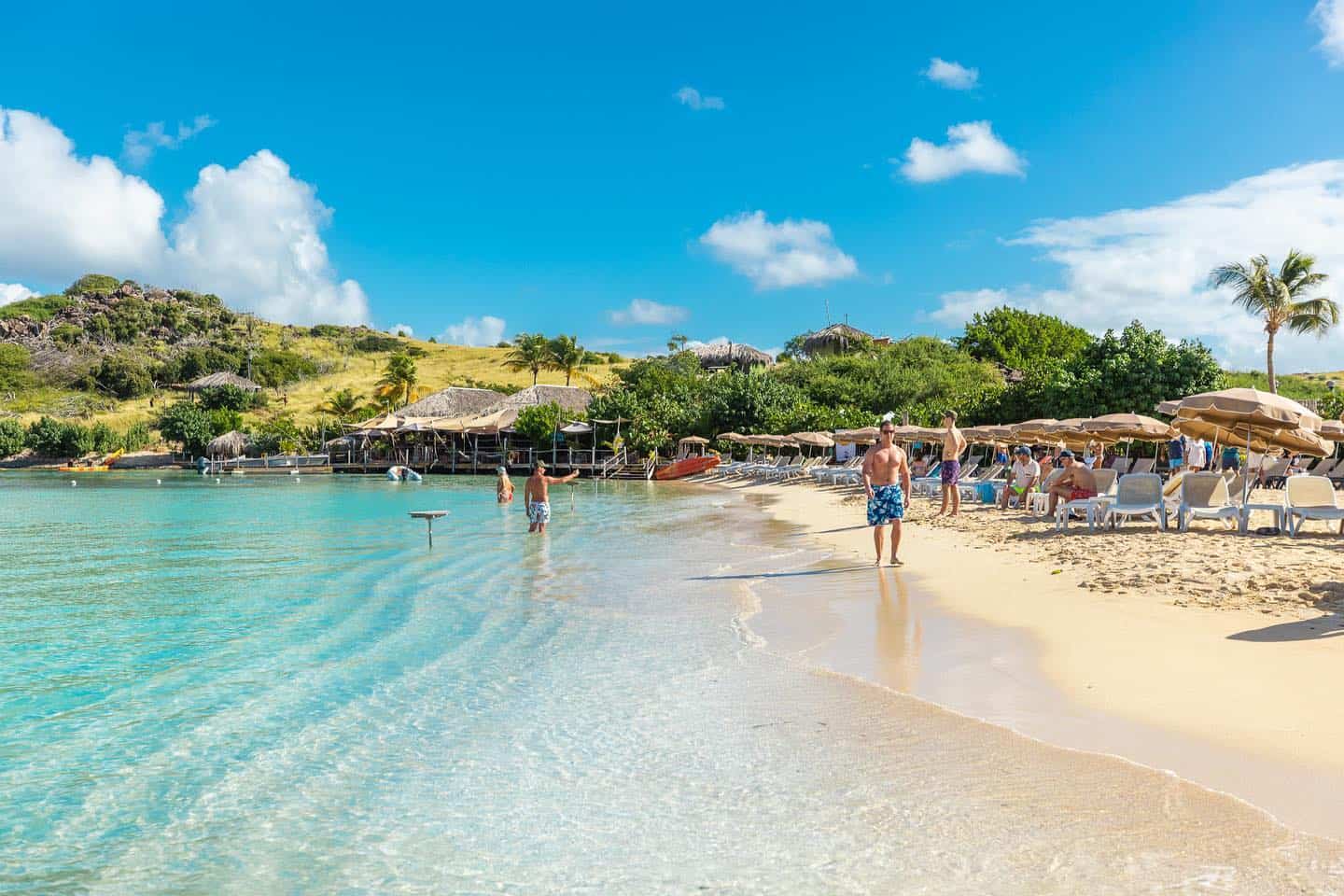 People in the water and walking the sand on Pinel Island