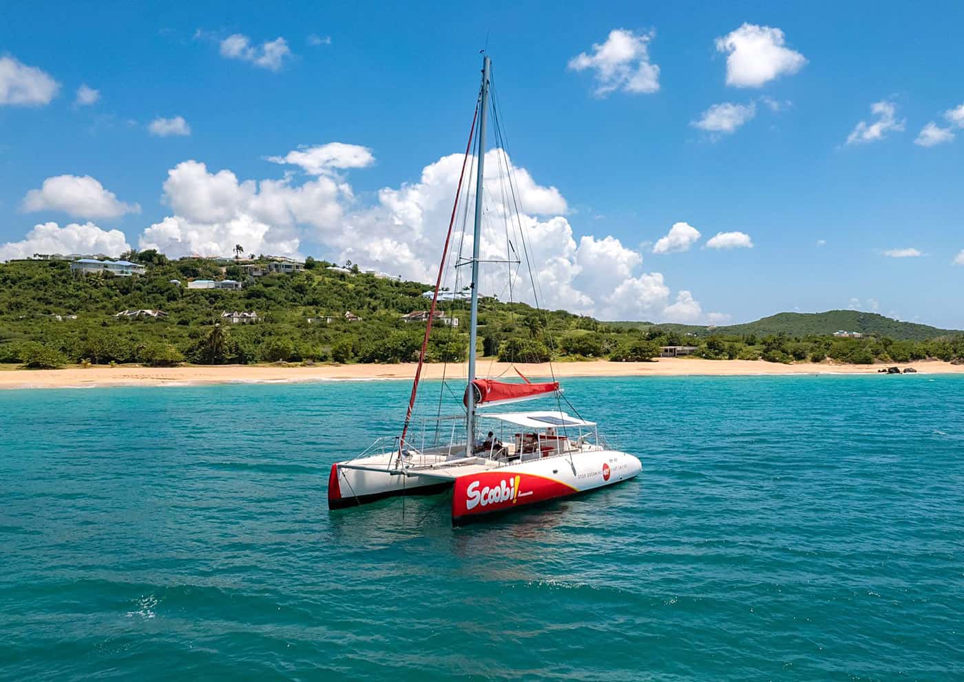 The red-and-white "Scoobi" sailing catamaran