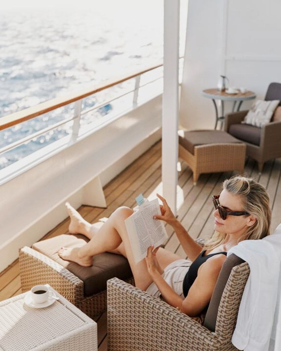 A woman relaxes on her private veranda on Crystal Serenity