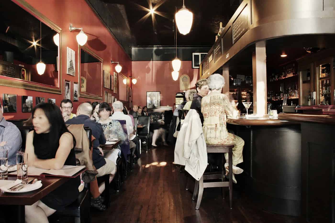 Diners sit in busy French brasserie with wood floors restaurant