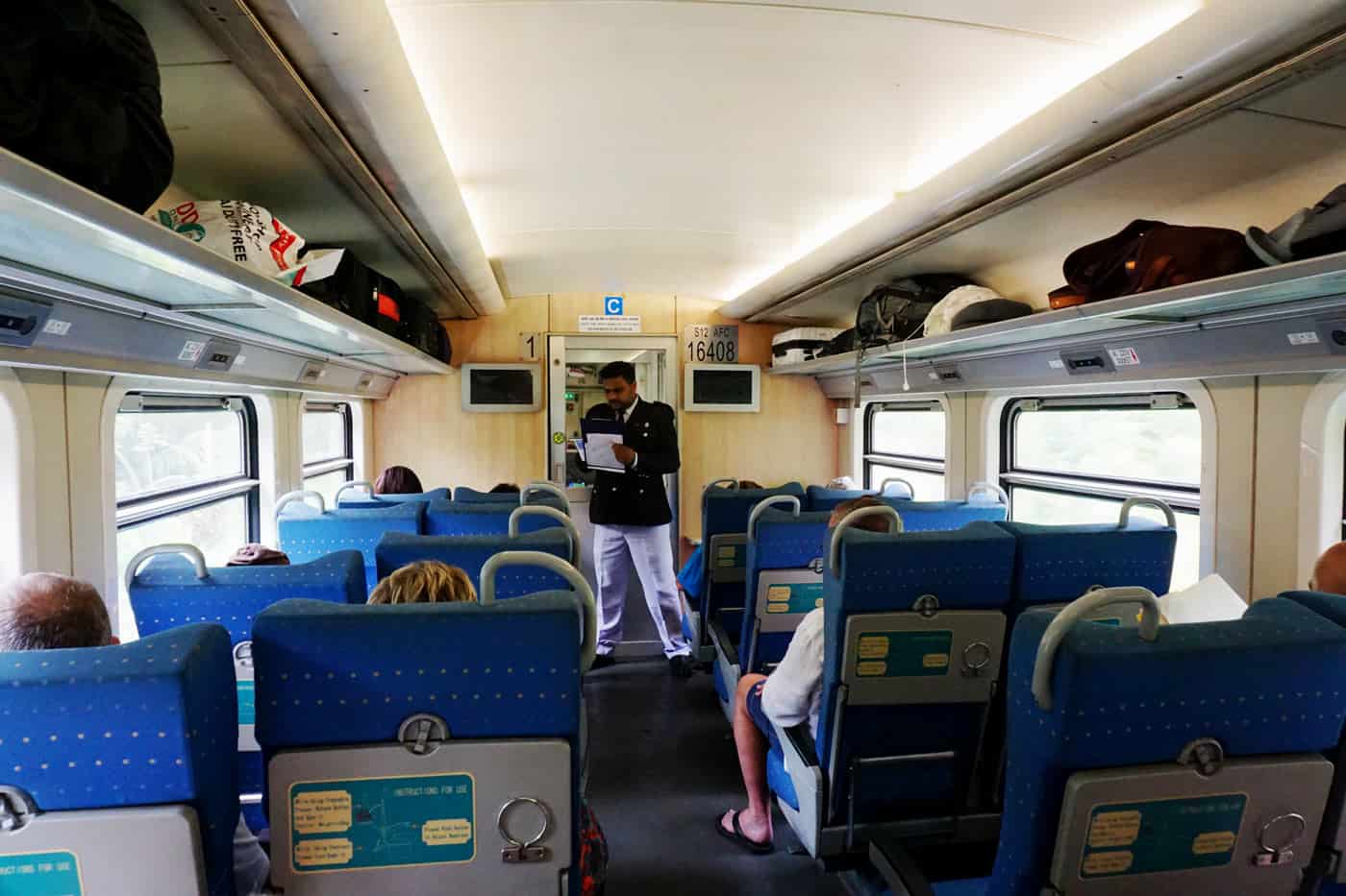 Blue padded seats inside first-class carriage on Kandy to Ella train