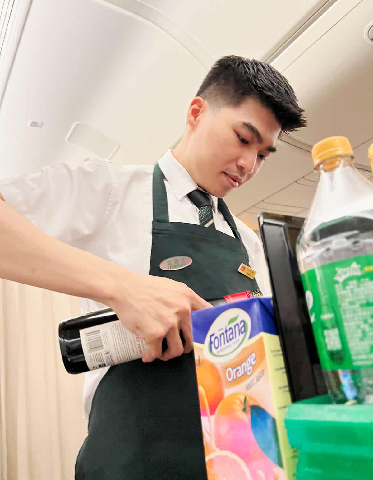 EVA Air flight attendant pouring wine