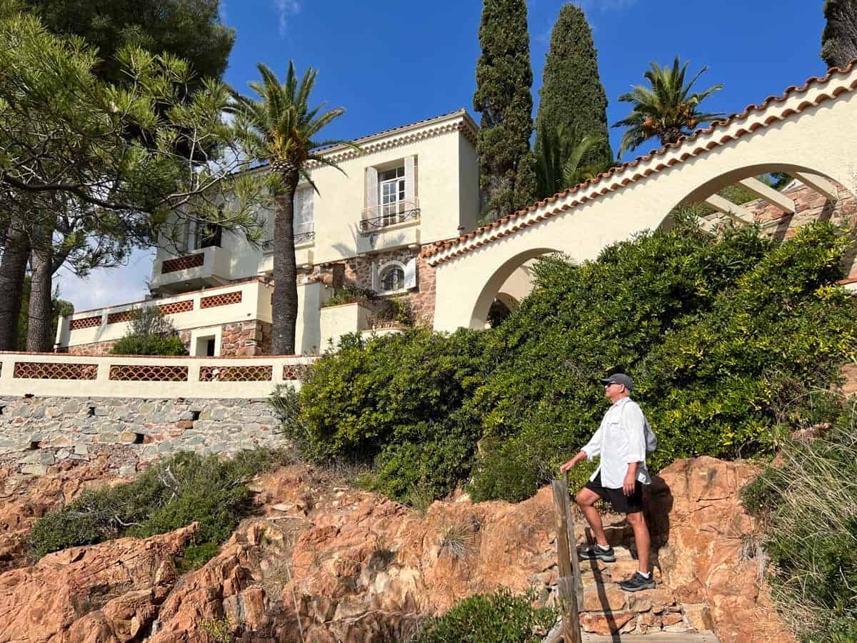 A hiker admires a villa on the Esterel coastal walking path near Saint-Raphael.