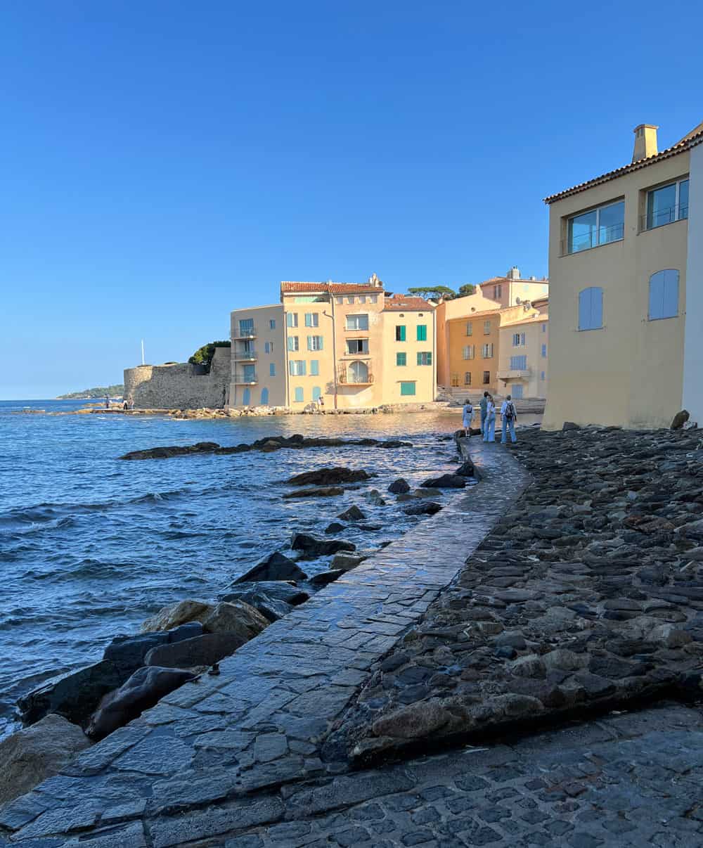 Colorful yellow buildings gleam in the sunshine, at the water's edge in Saint-Tropez.