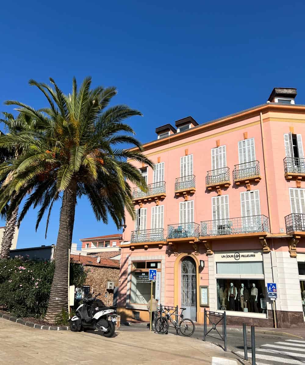 Pretty pastel pink building with wrought iron balconies in Saint-Raphael, France