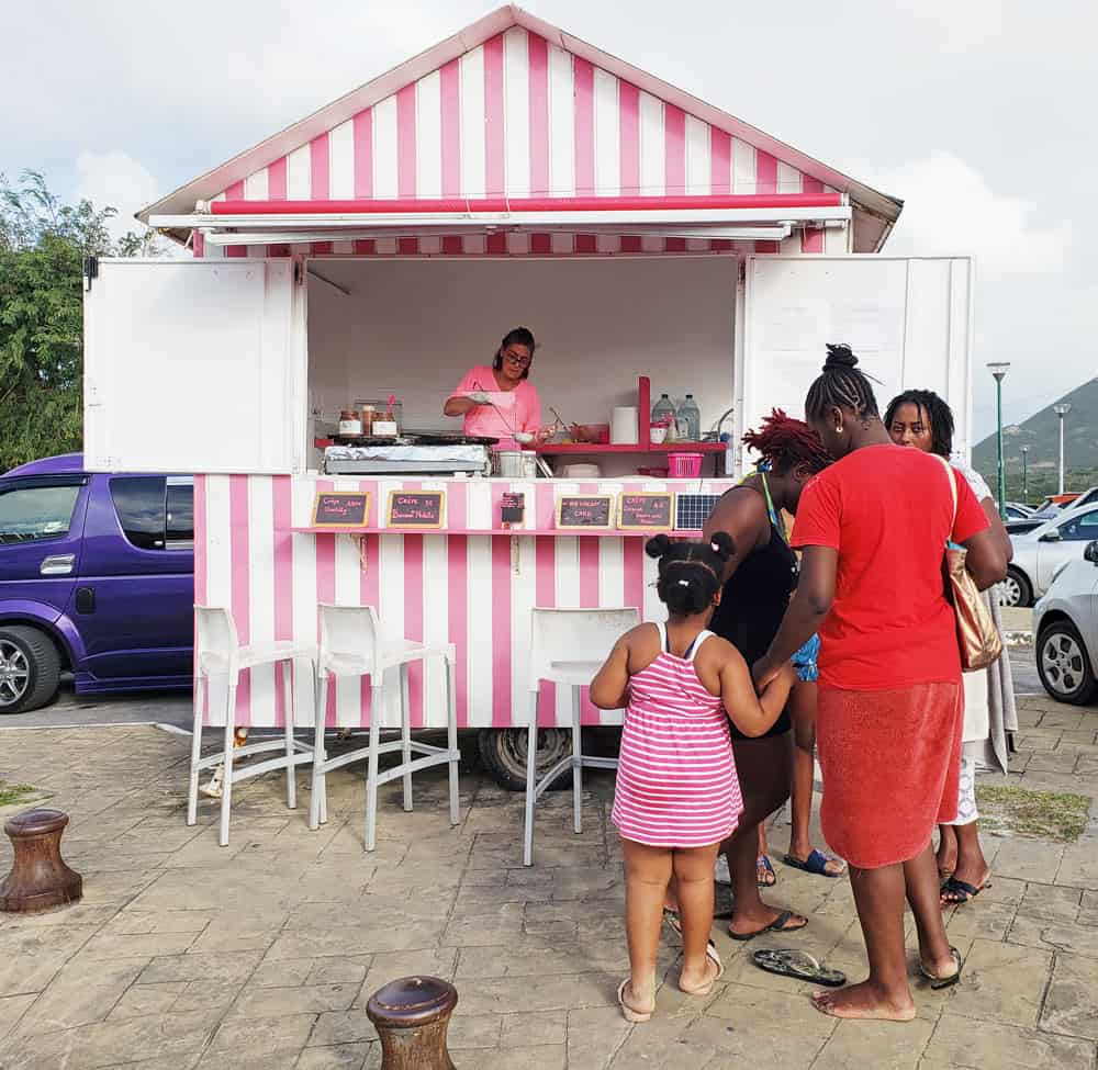 Mother and girl shop at pink-and-white creperie on St. Martin island