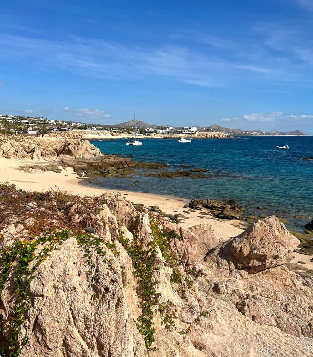 Blue ocean lapping golden sands of Chileno Bay, one of Cabo's best swimmable beaches
