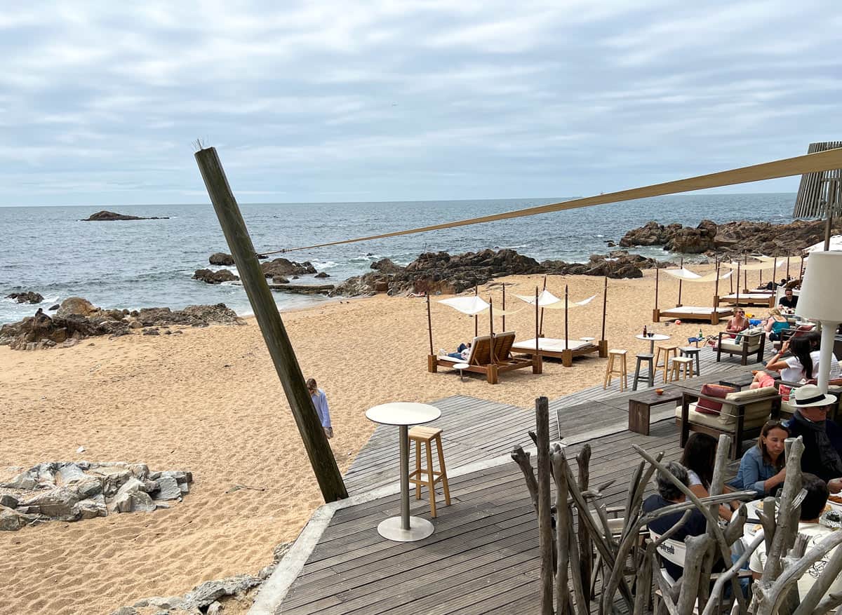 People enjoy a café on a sandy beach in Foz.